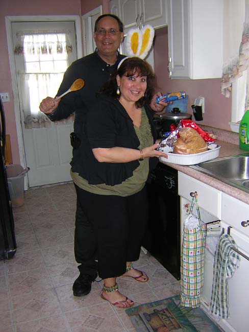 Chef Theresa unwraps a ham and warms it up.  Food service professional Little Tom supervises this enterprise.